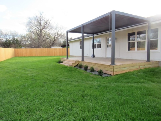 rear view of house with a lawn and a wooden deck