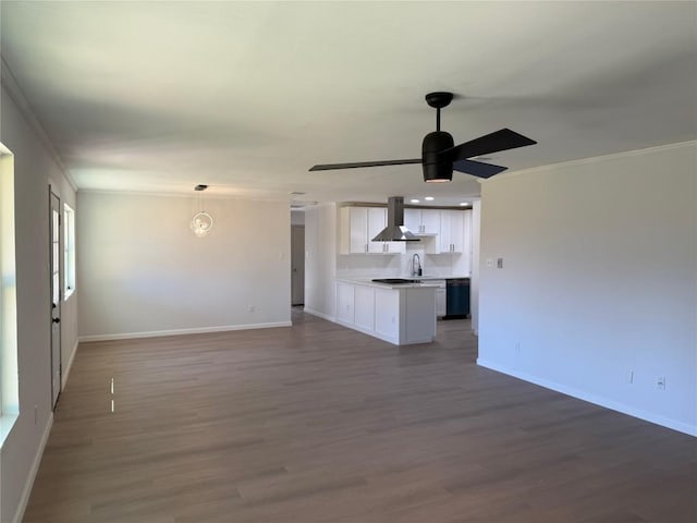 unfurnished living room with ceiling fan with notable chandelier, sink, wood-type flooring, and crown molding