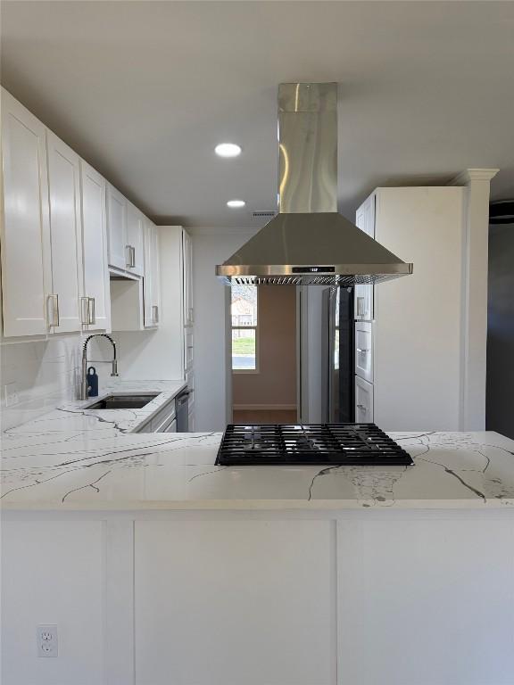 kitchen featuring kitchen peninsula, island exhaust hood, white cabinetry, and sink