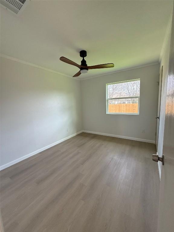 spare room featuring hardwood / wood-style flooring, ceiling fan, and ornamental molding