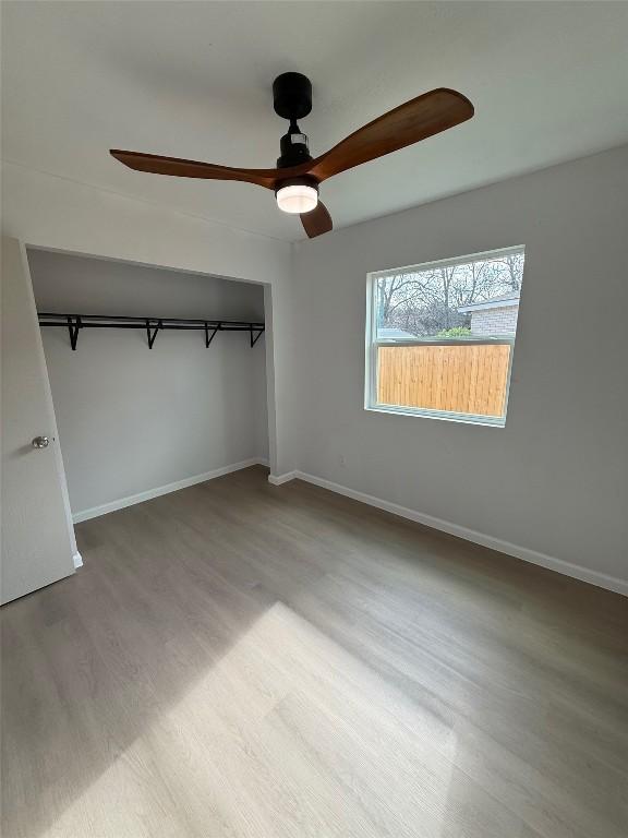 unfurnished bedroom with a closet, ceiling fan, and hardwood / wood-style floors