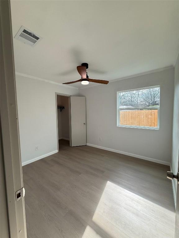 unfurnished room featuring ceiling fan, light hardwood / wood-style flooring, and ornamental molding