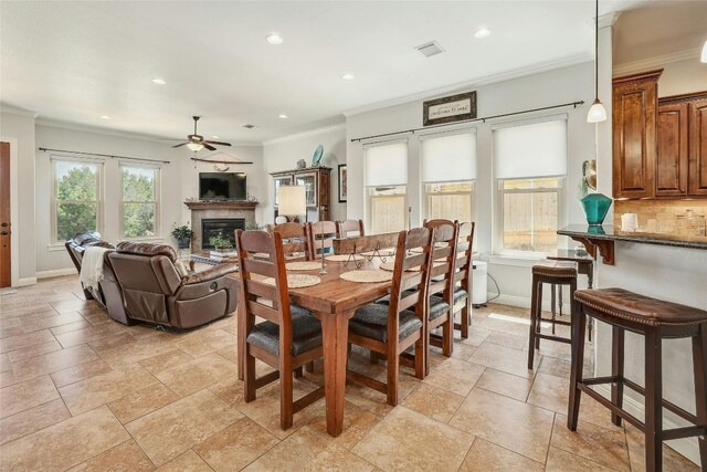 dining area featuring a wealth of natural light, ornamental molding, and ceiling fan