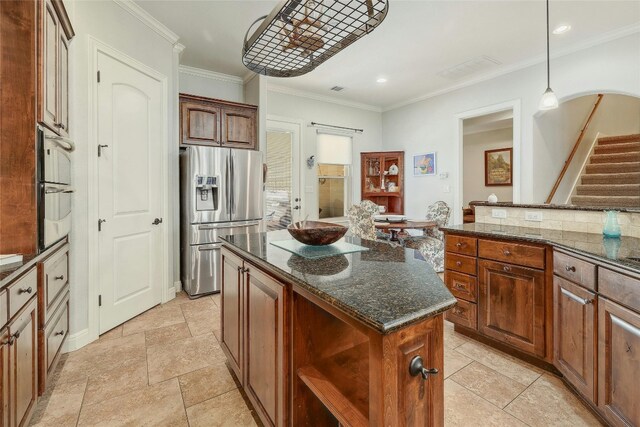 kitchen with ornamental molding, pendant lighting, dark stone countertops, stainless steel fridge with ice dispenser, and a center island