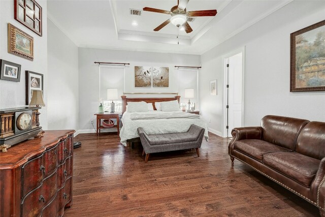 bedroom featuring a raised ceiling, ceiling fan, dark hardwood / wood-style floors, and ornamental molding