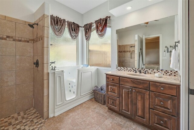 bathroom with decorative backsplash, vanity, and tiled shower