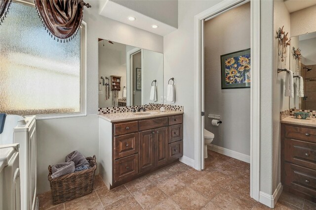 bathroom featuring washer / clothes dryer, decorative backsplash, vanity, and toilet