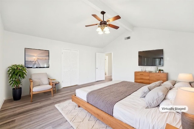 bedroom with a closet, lofted ceiling with beams, hardwood / wood-style flooring, and ceiling fan