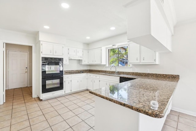 kitchen featuring dark stone counters, white cabinets, sink, double oven, and kitchen peninsula