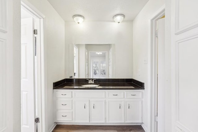 bathroom featuring vanity, wood-type flooring, and a textured ceiling