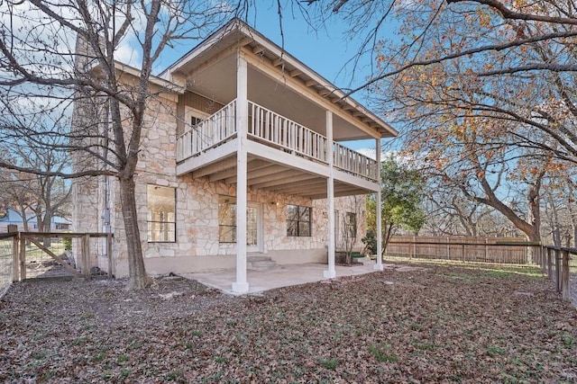 rear view of house featuring a patio and a balcony