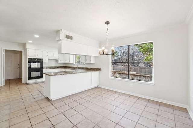 kitchen featuring white cabinetry, sink, kitchen peninsula, black double oven, and decorative light fixtures