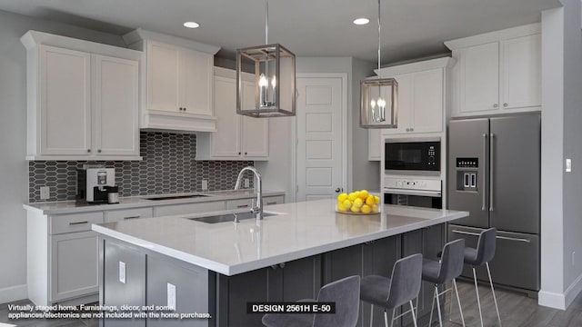 kitchen with pendant lighting, a kitchen island with sink, oven, sink, and stainless steel fridge with ice dispenser