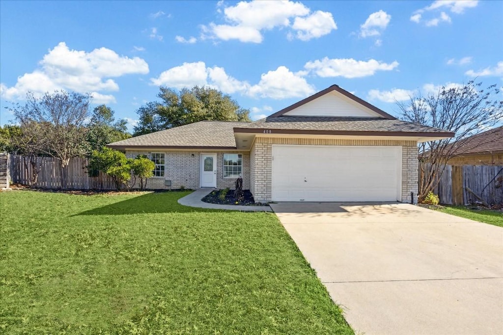 ranch-style house featuring a garage and a front lawn