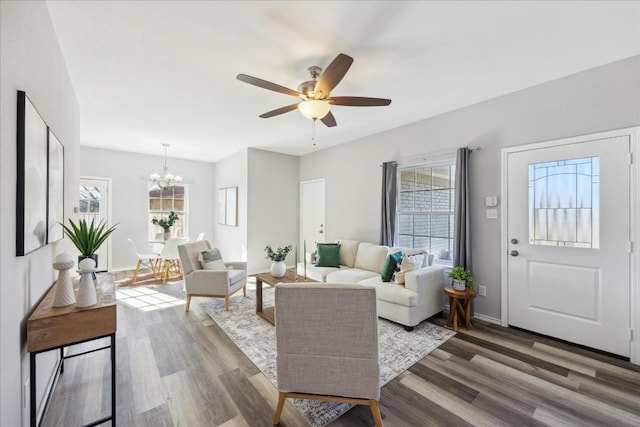 living room with hardwood / wood-style floors and ceiling fan with notable chandelier