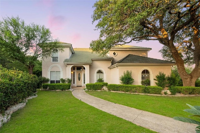 mediterranean / spanish-style house with a lawn