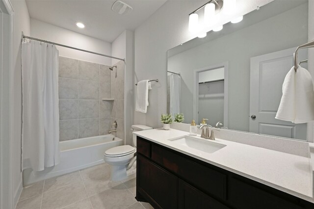 full bathroom featuring toilet, tile patterned floors, vanity, and shower / tub combo with curtain