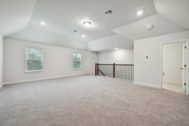 carpeted spare room featuring lofted ceiling