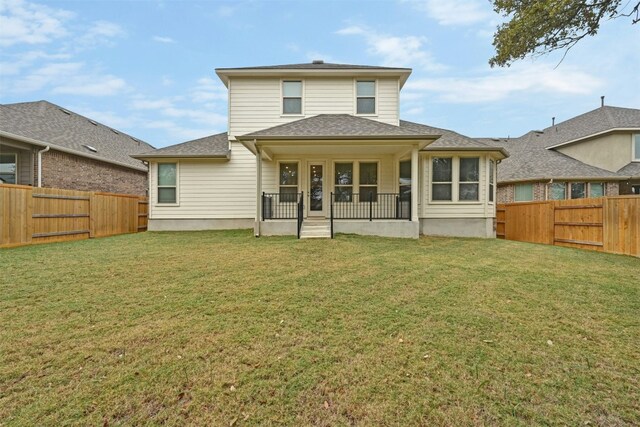 rear view of house featuring a yard