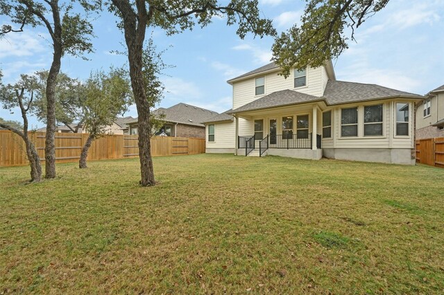 rear view of property with a lawn