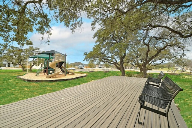 deck featuring a playground and a lawn