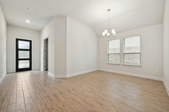 empty room featuring a chandelier and lofted ceiling