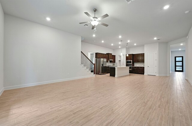 unfurnished living room featuring ceiling fan and light wood-type flooring