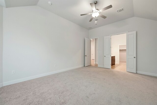 unfurnished bedroom featuring ceiling fan, light carpet, and vaulted ceiling