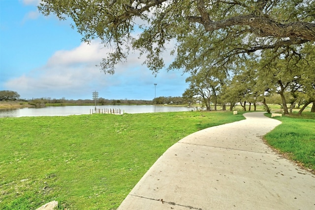 surrounding community with a yard and a water view