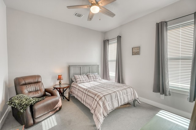 bedroom with multiple windows, ceiling fan, and light colored carpet