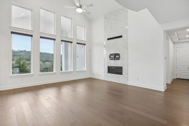 unfurnished living room with a high end fireplace, dark hardwood / wood-style floors, high vaulted ceiling, and ceiling fan