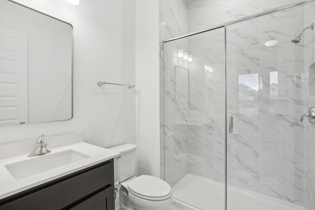 bathroom with vanity, toilet, and a shower with shower door