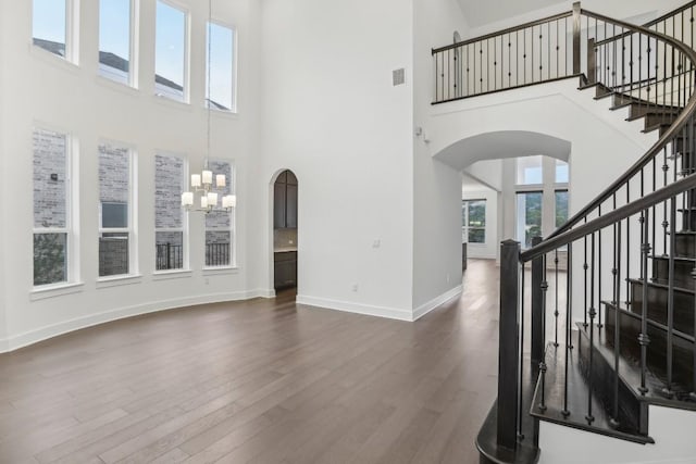 living room featuring a high ceiling, dark hardwood / wood-style flooring, and a notable chandelier