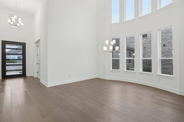 entrance foyer featuring a chandelier, a high ceiling, and dark wood-type flooring