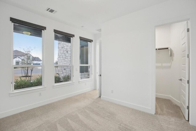 carpeted spare room featuring a healthy amount of sunlight