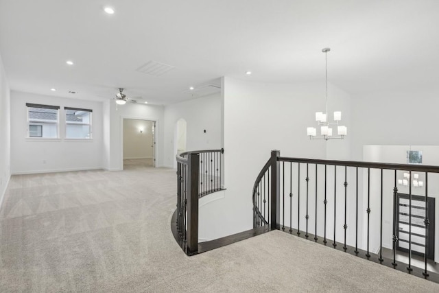 corridor featuring light carpet and a chandelier