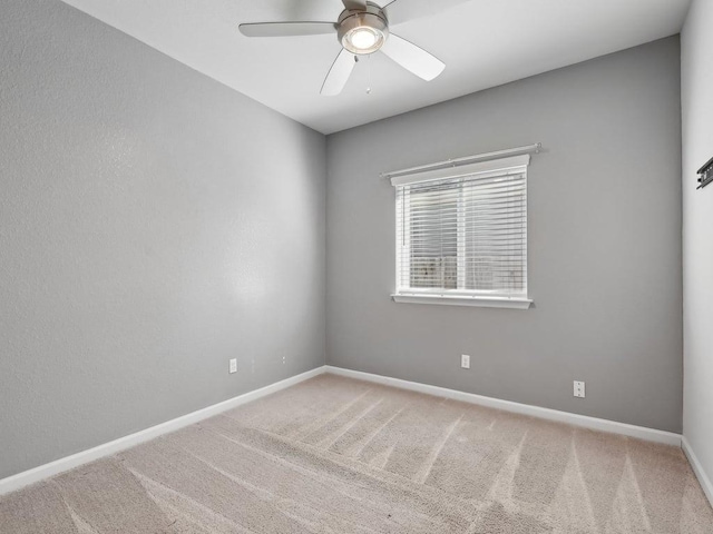 spare room featuring ceiling fan and carpet