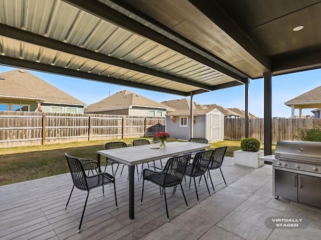 view of patio / terrace featuring grilling area and a storage shed