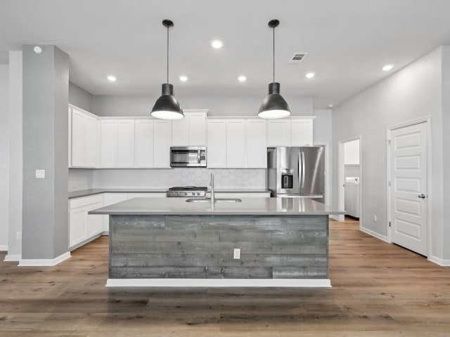 kitchen featuring white cabinetry, sink, pendant lighting, a center island with sink, and appliances with stainless steel finishes