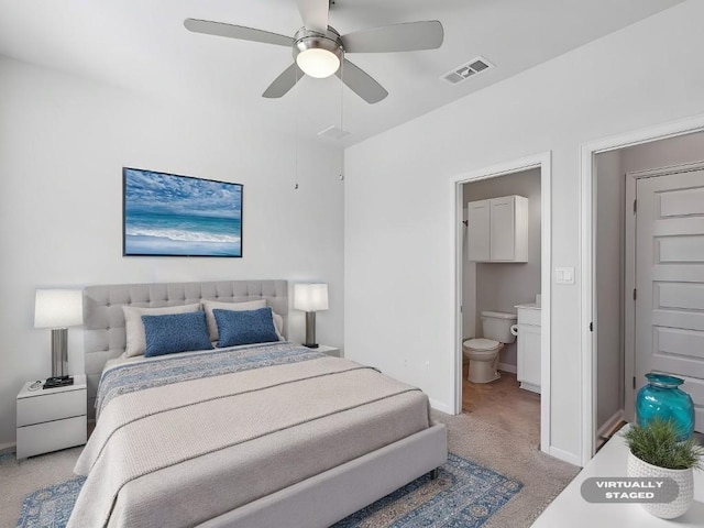 carpeted bedroom with ceiling fan and ensuite bath