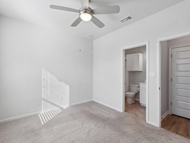 unfurnished bedroom featuring ensuite bath, ceiling fan, and light colored carpet