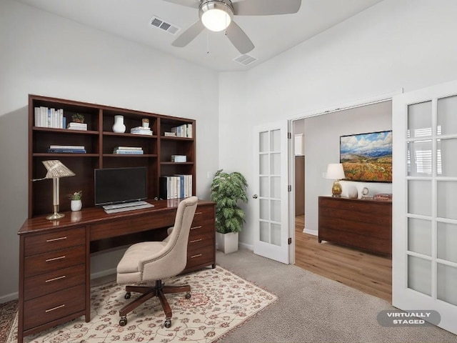 carpeted office space featuring french doors and ceiling fan