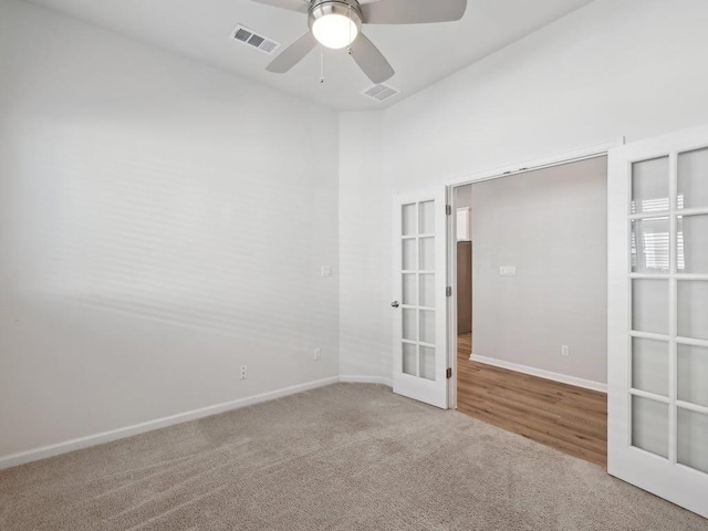 carpeted empty room with french doors and ceiling fan