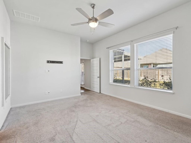 carpeted spare room featuring ceiling fan