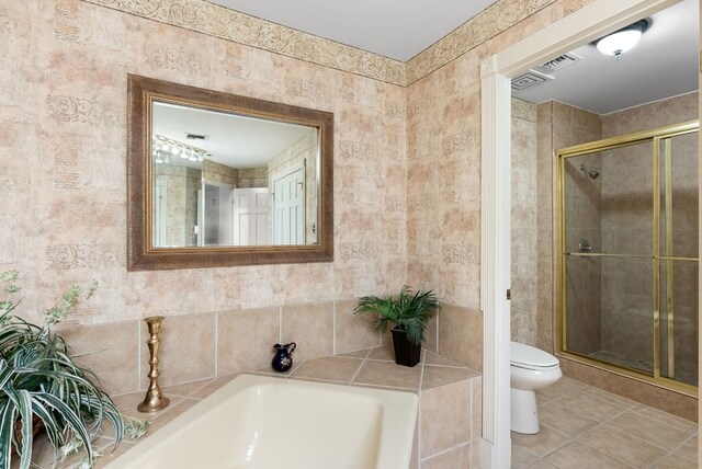 bathroom with tile patterned floors, separate shower and tub, and toilet