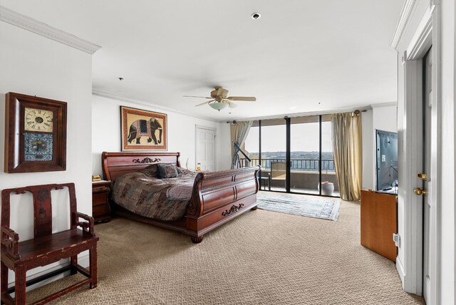 carpeted bedroom featuring access to exterior, ceiling fan, ornamental molding, and a wall of windows