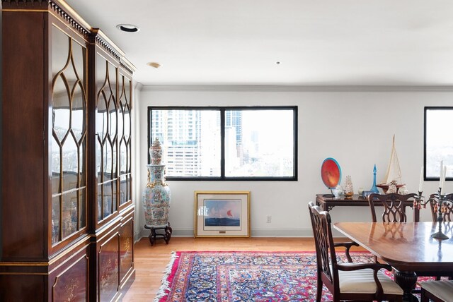 dining room featuring light wood-type flooring and crown molding