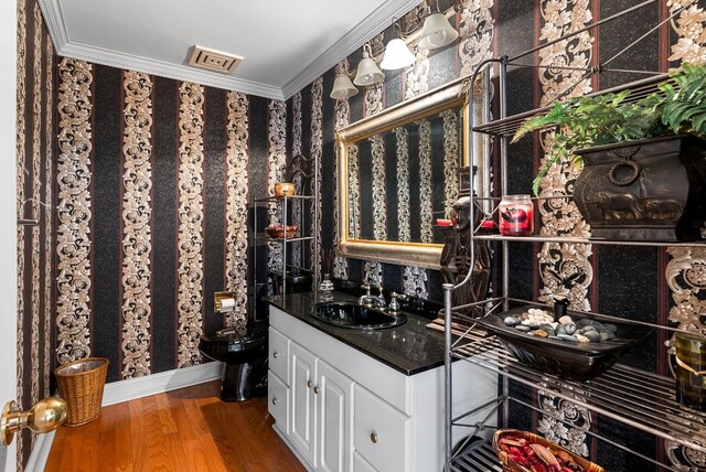 wine area featuring hardwood / wood-style floors, wet bar, and crown molding