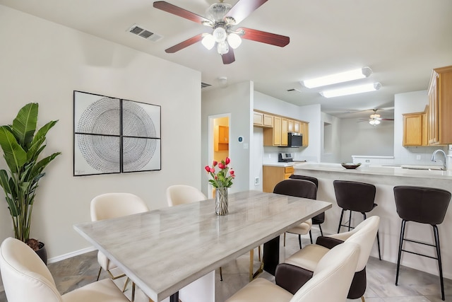 dining area with ceiling fan and light tile patterned floors