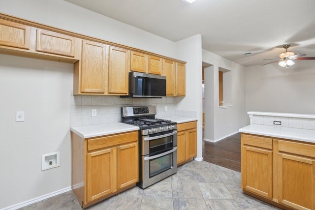 kitchen featuring range with two ovens, decorative backsplash, and ceiling fan